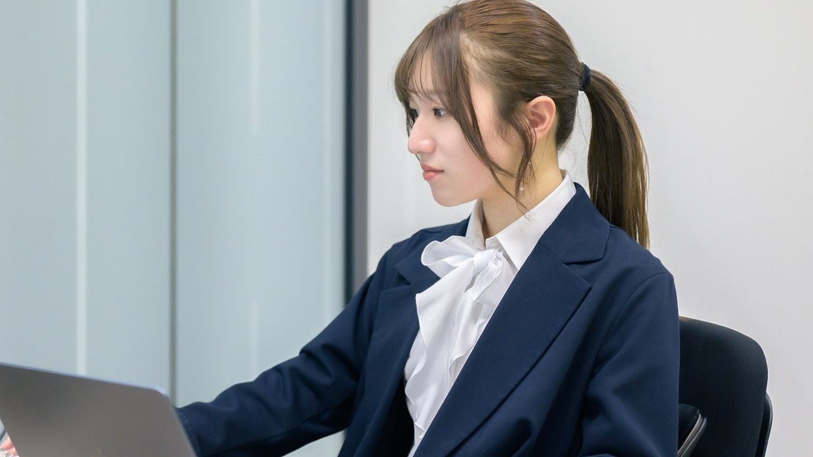 ノートパソコンに向かって作業している担当者の横顔